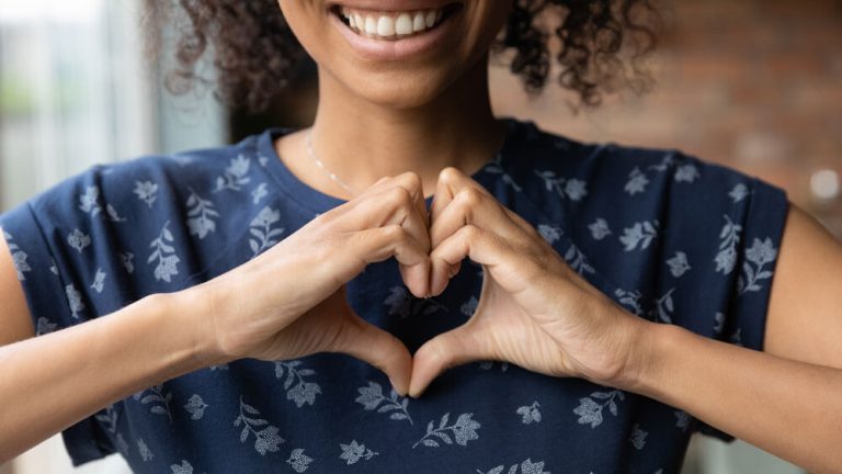 close up of a person holding their hards in the shape of a heart